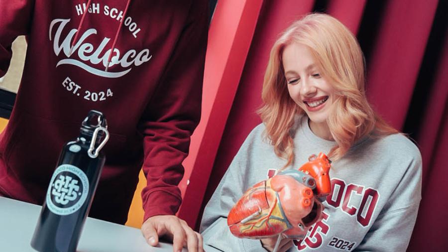 studentessa con felpa grigia personalizzata Weloco e borraccia scuola