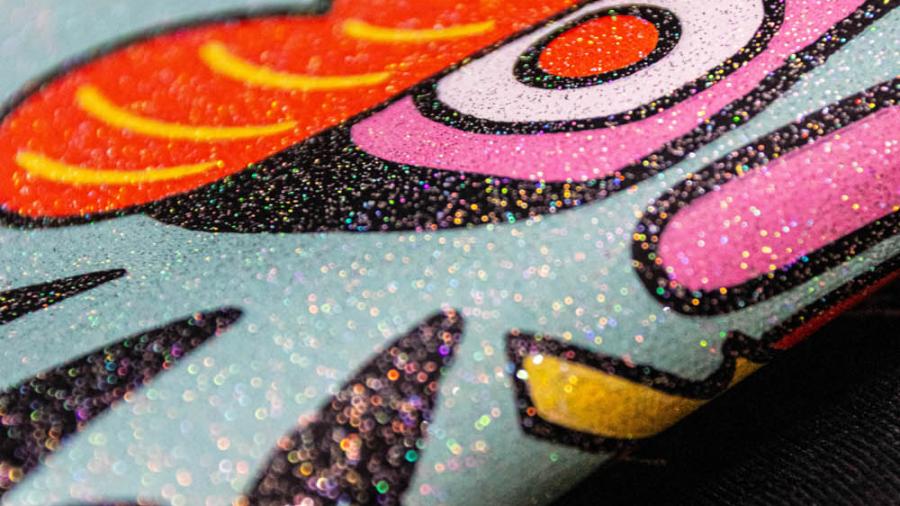 Dettaglio macro texture glitter transfer DTF su tessuto