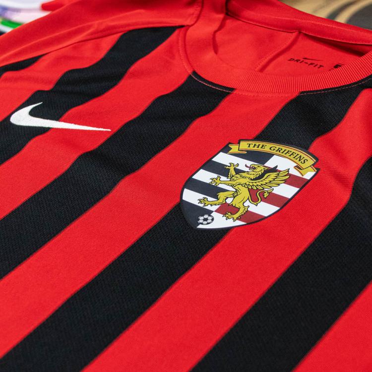 Dettaglio transfer DTF con colla nera su maglia sportiva rossa e nera a righe