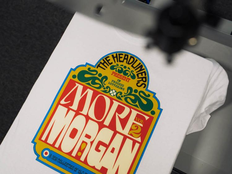 Grafica multicolore con colori vibranti stampata in DTI in fase di pressatura su maglietta bianca